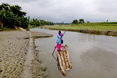 Info Lady Mahfuza crosses a waterway on a makeshift banana palm raft. In rural Bangladesh the Info Ladies are bringing internet services to men and women who need information but don't have the means...