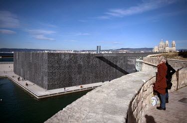 Two women looking at the Museum of European and Mediterranean Civilisations (MuCEM), by architect Rudy Ricciotti, from the Promenade Louis Brauquier.
