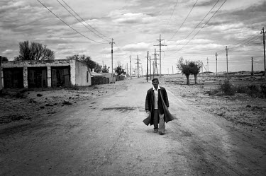 A man walks along an empty road. During the 1950s and the 1960s the rivers that feed the Aral Sea (the Amu Darya and the Syr Darya) were diverted for irrigating cotton and other crops. This caused the...
