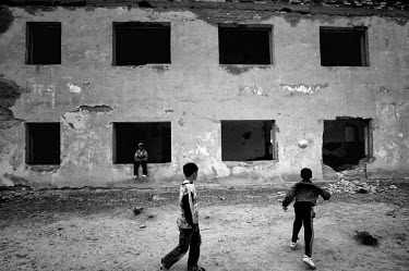 Young boys playing football near an abandoned house. During the 1950s and the 1960s the rivers that feed the Aral Sea (the Amu Darya and the Syr Darya) were diverted for irrigating cotton and other cr...