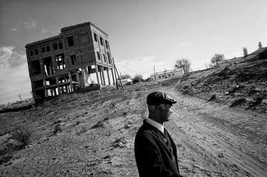 A man walks beside a decaying and abandoned building. During the 1950s and the 1960s the rivers that feed the Aral Sea (the Amu Darya and the Syr Darya) were diverted for irrigating cotton and other c...