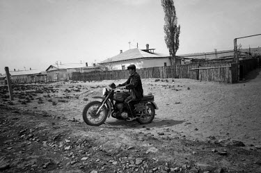 A man drives his bike through the sand. During the 1950s and the 1960s the rivers that feed the Aral Sea (the Amu Darya and the Syr Darya) were diverted for irrigating cotton and other crops. This cau...