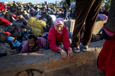 Nora El-KouKhou (centre wearing as red jacket) tries to climb a wall to escape from a stampede as hundreds of porters try to get first in line to cross the Moroccan-Spanish border. Hundreds of people...