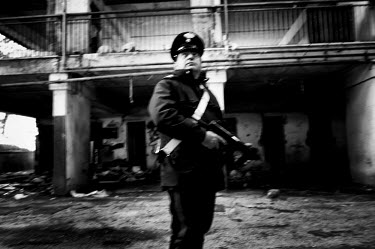 A policeman holding a machine gun while on patrol in the Vele di Scampia (Sails of Scampia), a housing complex (by architect Franz di Salvo) built during the 1960s and early 1970s. Seven separate Zigg...
