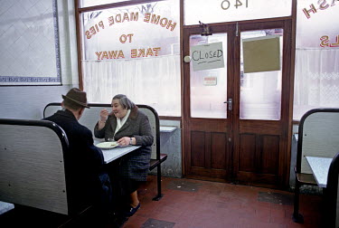 An elderly couple eating in an eel, pie and mash shop in the east end of London.