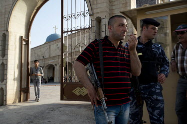 Kurdish police and local protection militias guard the entrance to the Saint Yohana Church in the Christian town of Karaqosh located on the Nineveh Plain just 20 kilometres from Mosul, one of the most...