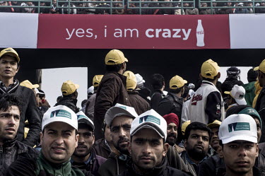 Fans at the Firozshah Kotla cricket stadium in New Delhi during a match between India and Pakistan. Above the crowd, an advertising hoarding for Coca-Cola reads: 'yes, i am crazy'.