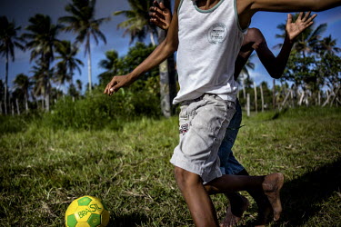 Boys play football in a field on the road between Conde and Acaraju in Northeast Brazil.