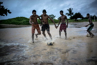 Boys play football on a beach in Recife.