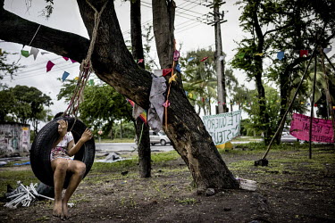A girl swings on a tyre tied to a tree in the Occupy Estelita movement basecamp across from Pier Estelita in Recife. Occupy Estelita is a protest movement meant to prevent developers from building new...