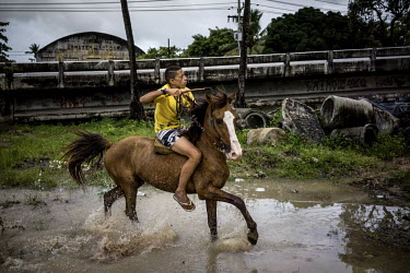 A boy rides a horse near the Occupy Estelita movement basecamp across from Pier Estelita in Recife. Occupy Estelita is a protest movement meant to prevent developers from building new luxury high rise...