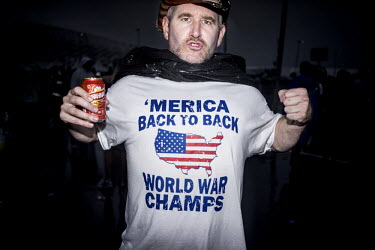A fan of the United States football team prepares for his team's match against Germany in Recife. His T-shirt reads: ' MERICA Back to Back - World War Champs'