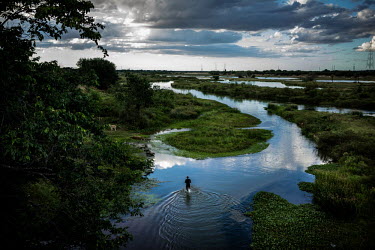 A man crosses a small river along the road between Fortaleza and Canoa Quebrada.