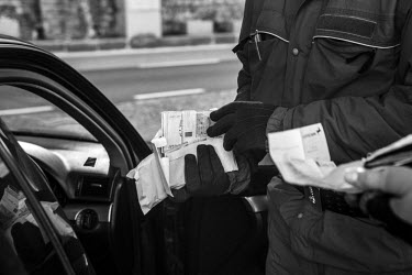 An Italian customs official, with the Guardia di Finanza, holds envelopes stuffed with British Pounds which were found in the possession of two Russians crossing into Italy from Switzerland via the Ch...