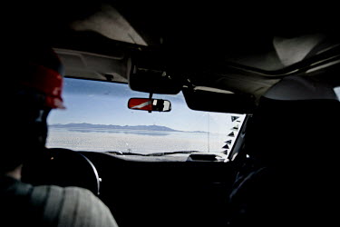 A vehicle drives into the 4000 square miles (10,000 sq km) of the Salar de Uyuni salt flat.