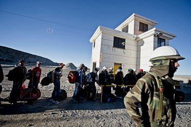 Workers are searched at the end of their two week shift at the lithium extraction facility, 14 kilometres into the Salar de Uyuni, before boarding the bus that will take them to the town of Uyuni for...