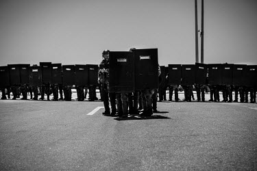 Riot police protect the beaches and the tourists from a protest of Union construction workers near the beaches of Fortaleza.  Their demands for pay increases and better health care was met by riot pol...