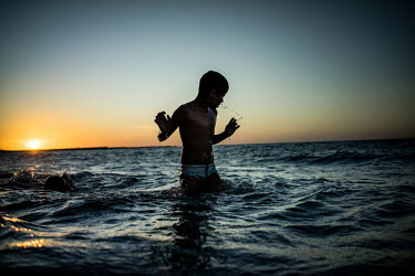 A boy swims in the last light of the day on the beach in Fortaleza.