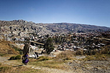 Marta La Altena, a Cholita or wrestler of native Aymara descent, walks up a valley towards the main road where a car will take her to the 12 October Stadium for an evening bout.