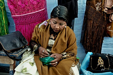 Carmen Rojas, a Cholita or wrestler of native Aymara descent, takes a pinch of Coca Leaf about an hour before she enters the ring for a bout. Coca is widely chewed amongst the Aymara and Quechua popul...