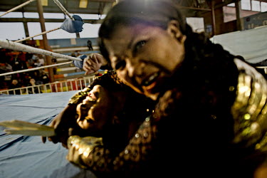 Two Cholitas (wrestlers of native Aymara descent) grapple during a bout at the 12 October Stadium in the El Alto district.