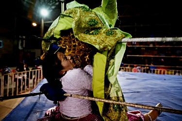 Marta La Altena (a Cholita or wrestler of native Aymara descent) humiliates her opponent as befits her 'evil' stage persona, to the delighted outrage of the crowd during a bout at the 12 October Stadi...