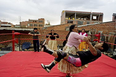 Mercedes La Extremista, a Cholita or wrestler of native Aymara descent, executes a brutal 'clothesline' move on her male opponent during a training session in Zona Complejo, El Alto. The male wrestler...