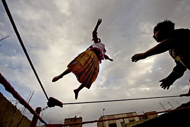 Cholita (wrestler of native Aymara descent) Yolanda La Amorosa practices a flying leap from the top rope during training session in El Alto, her unfortunate opponent will have to break her fall.