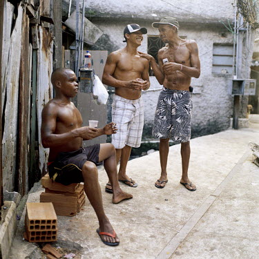 Three men smoking and drinking. At 115 years old, Providencia is Rio de Janeiro's oldest favela, originally formed when veterans of the bloody Canudos war in Brazil's northeast moved to the city. In A...