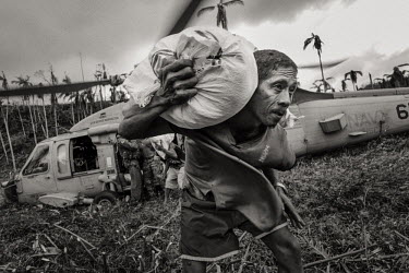 A villager hauls relief goods from a US Navy helicopter. Typhoon Haiyan, or Yolanda as it is known in the Philippines, made landfall on 8 November 2013 and was one of the deadliest typhoons to hit the...