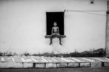 A boy sits in the window of his house in Sao Jose, a small Bahian town.