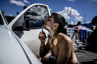 An Argentina fan shaves in a car mirror at the makeshift camp which fans have set up in Rio de Janeiro ahead of the 2014 Football World Cup final between Germany and Argentina. Germany won the match 1...