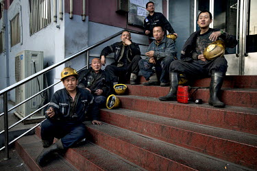 Miners sit and smoke before a shift at the Datong Coal Mine Group's (Tong Mei) Mei Yukou mine.