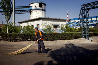 A man sweeps coal dust off a road at the Datong Coal Mine Group's (Tong Mei) Tashan Coal Mine complex.