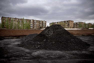 A pile of coal in a yard in front of a residential complex housing workers, and their dependants, of the Datong Coal Mine Group's (Tong Mei) Yong Ding Zhuang coal mine.