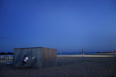 Boys playing football on the beach at Torreblanca (Fuengirola), using a storage shed as a goal.  The long broad beach, stretching from Fuengirola, is crowded with tourists during the day throughout th...
