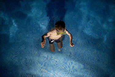 A child swimming in a pool. The long broad beach, stretching from Fuengirola, is crowded with tourists during the day throughout the summer months but in the mornings and late eveings, the sun hungry...