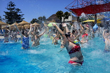 Tourists dancing in one of the many pools at the waterpark Parque Acuatico Mijas. The long broad beach, stretching from Fuengirola, is crowded with tourists during the day throughout the summer months...