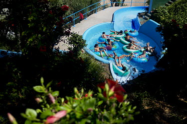 Tourists riding one of the many waterslides in the waterpark Parque Acuatico Mijas. The long broad beach, stretching from Fuengirola, is crowded with tourists during the day throughout the summer mont...