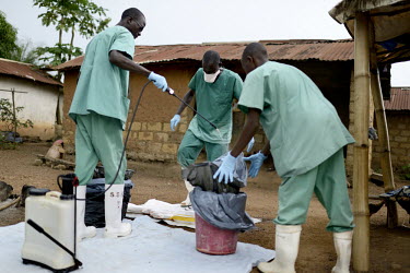 MSF (Doctors Without Borders) staff disinfect a nurse from a private clinic in the village. An Ebola virus epidemic of unprecedented proportions has broken out in West Africa killing at least 539 peop...