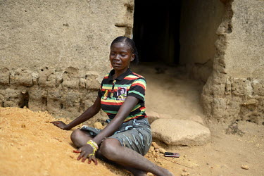 Kumba Conde (25) sits on the ground outside her house and cries for her sister Marie Conde (14) who died that morning after being infected with the Ebola virus. An Ebola virus epidemic of unprecedente...