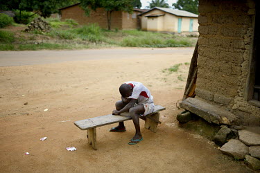 A boy sits and cries after a truck from the Red Cross arrived in Koundony with the body of Marie Conde (14) who died that morning after becoming infected with the Ebola virus. An Ebola virus epidemic...