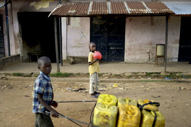 A boy pushes a cart loaded with water containers in Gueckedou, the main town near the border of Liberia. An Ebola virus epidemic of unprecedented proportions has broken out in West Africa killing at l...