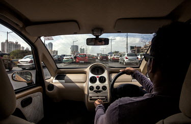 A young professional drives his new Nano Twist car in the midst of Mumbai traffic.