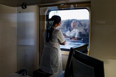Carina Sadirdinova, the nurse and receptionist on the Matvei Mudrov, stands at the window of the train after a day's work, looking outside.   The Matvei Mudrov train is a medical train operated by Rus...