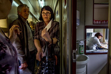 Patients line up aboard the Matvei Mudrov medical train to get the results of their pathology tests.  The Matvei Mudrov train is a medical train operated by Russian Railways along the course of the Ba...