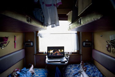 Two nurses on the Matvei Mudrov medical train watch a soap opera in their compartment.   The Matvei Mudrov train is a medical train operated by Russian Railways along the course of the Baikal Amur Mag...