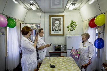 The crew of the Matvei Mudrov train celebrates the birthday of the medical director, Vera Chebakova. A portrait of Doctor Matvei Mudrov, after whom the train was named. hangs on the wall above the tab...