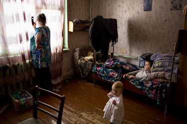 Olga Kolmogorova tries to get a mobile phone signal to make a call. She and her husband Piotr are raising their three grandchildren, as the children's father is often away, working in the taiga, and t...