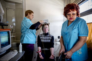 A doctor and nurse on board the Matvei Mudrov record an electroencephalogram of Nadegda Gaskevitch who struck her head in a fall in 2003 and now needs regular treatment.  The Matvei Mudrov train is a...